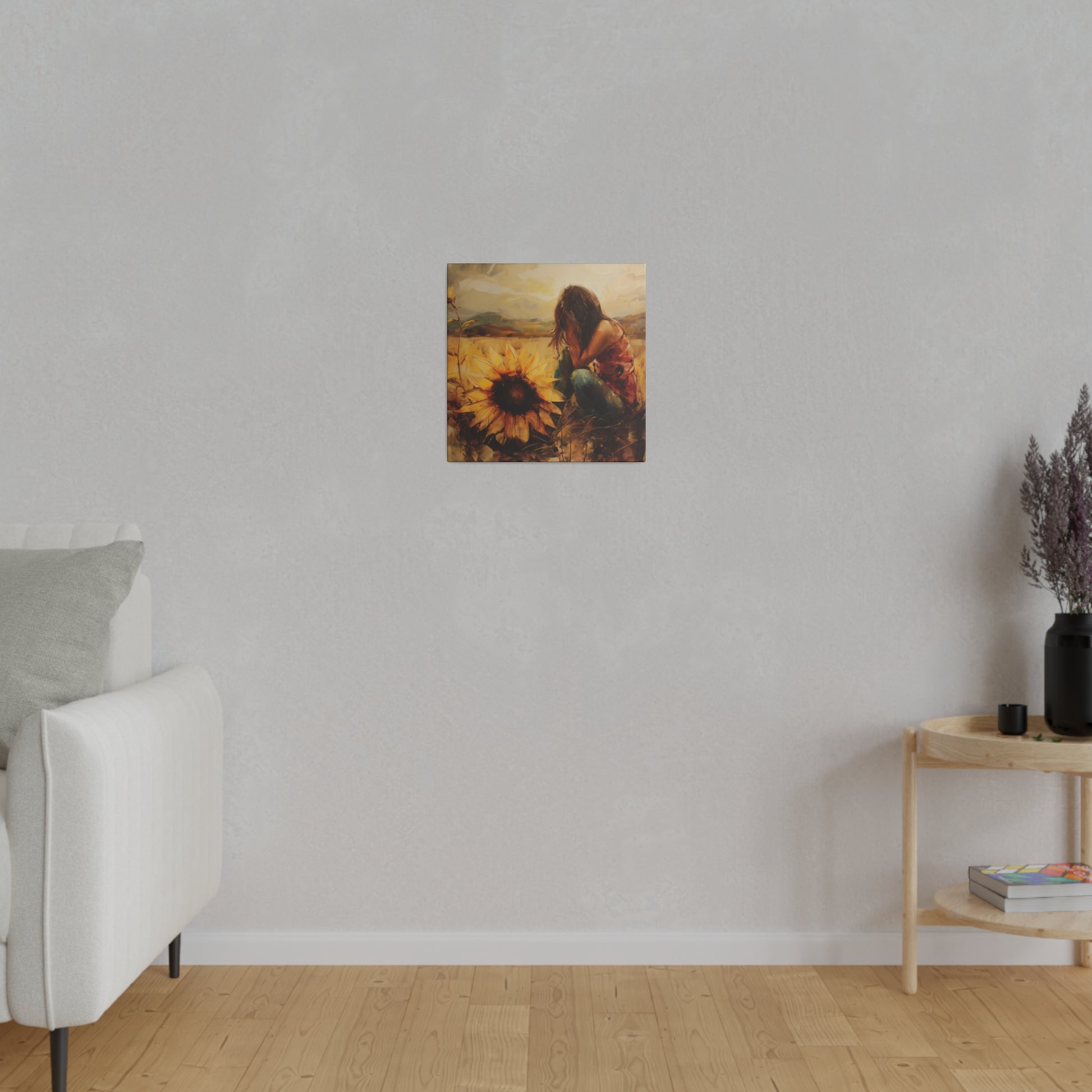 A framed Elena Duval: Solace in Solitude exclusive canvas print of a person among sunflowers, capturing the human experience, is hung on a plain wall in a minimalist room.
